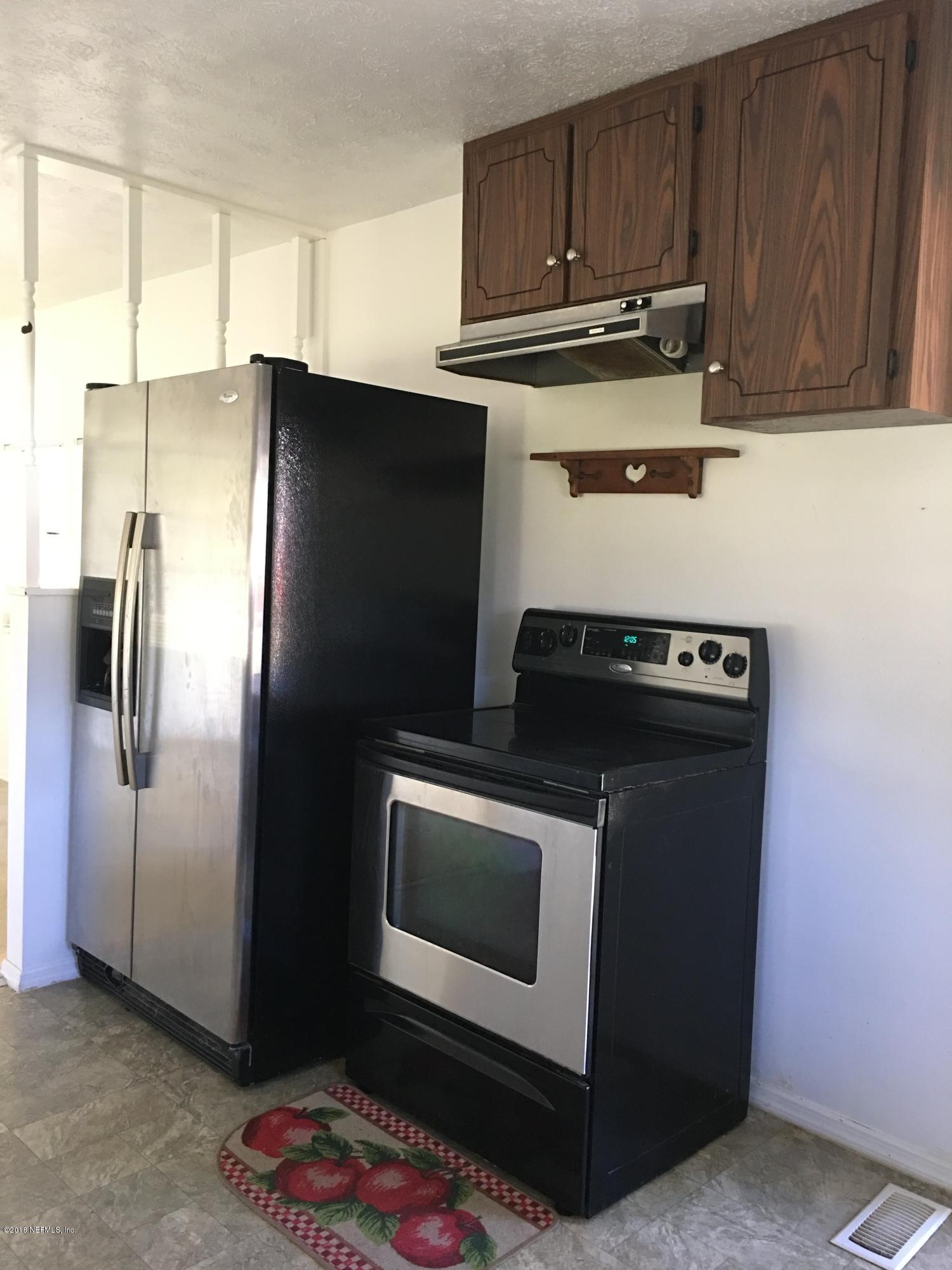 54199 Roy Booth Road Callahan, FL 32011 - Photo 8 of 23 a kitchen with stainless steel appliances granite countertop a refrigerator a stove and a sink