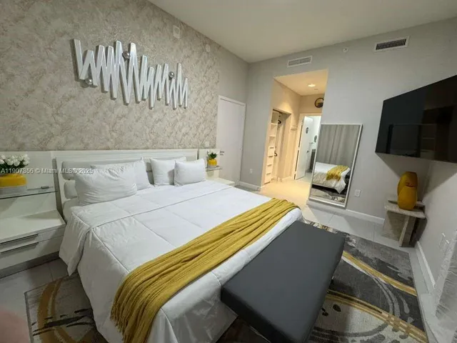 a bedroom with a bed and flat screen tv