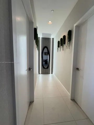 a view of a hallway to a livingroom and a window
