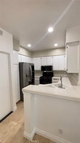 a view of kitchen with refrigerator sink and cabinets