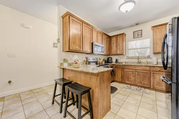a kitchen with stainless steel appliances granite countertop a refrigerator sink and cabinets