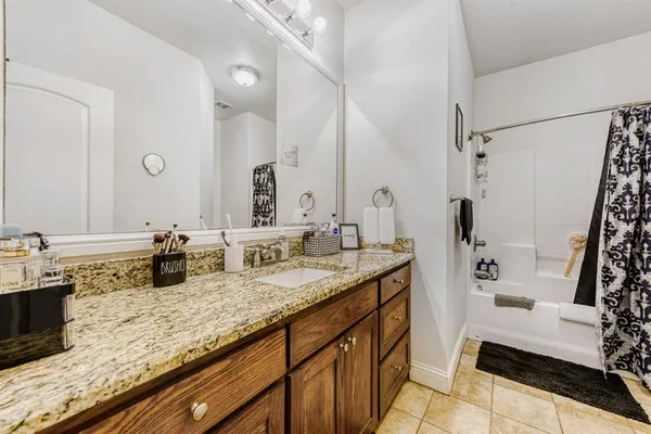 a bathroom with a granite countertop sink a mirror a vanity and shower