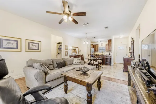 a living room with furniture kitchen view and a chandelier