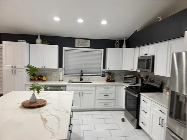 a kitchen with a sink stainless steel appliances and cabinets