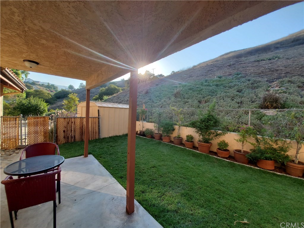 8260 Weirick Road Corona, CA 92883 - Photo 28 of 40 a view of a backyard with table and chairs potted plants and a palm tree