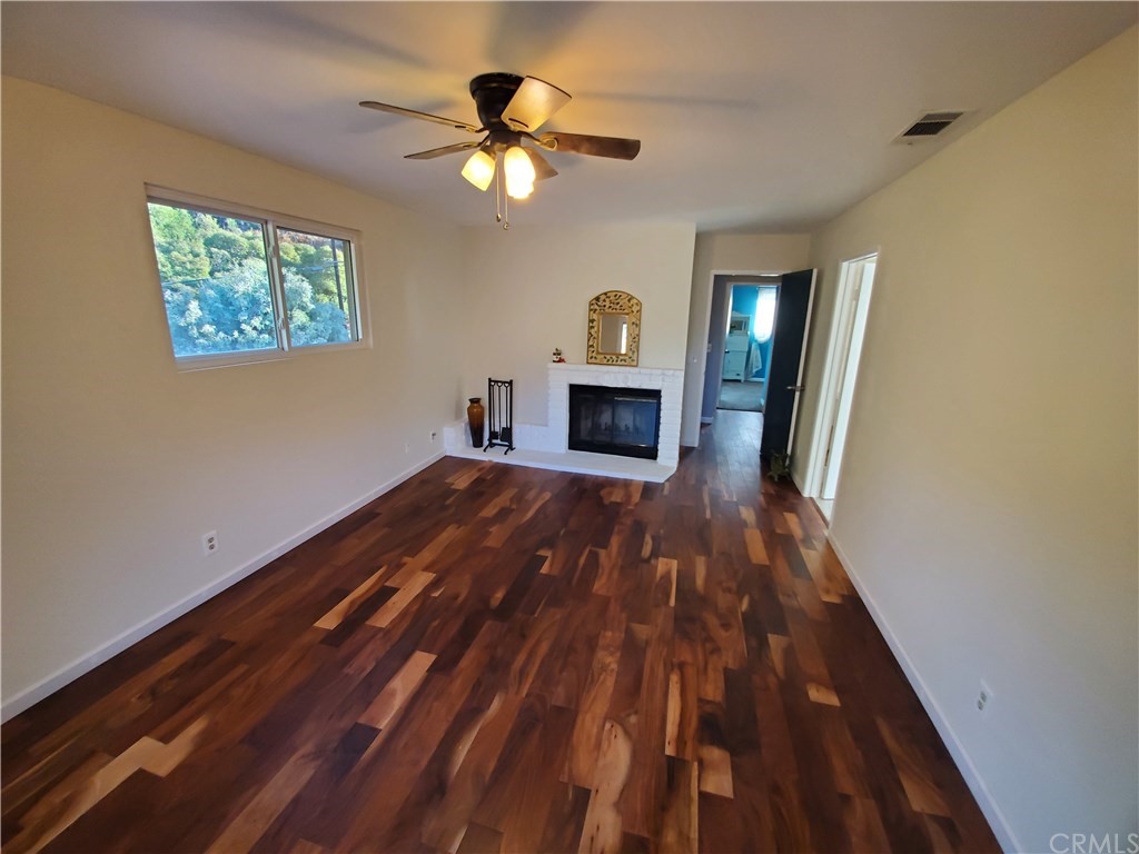 8260 Weirick Road Corona, CA 92883 - Photo 6 of 40 an empty room with wooden floor fireplace and window