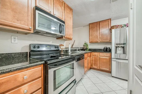 a kitchen with stainless steel appliances granite countertop a stove a microwave and a refrigerator