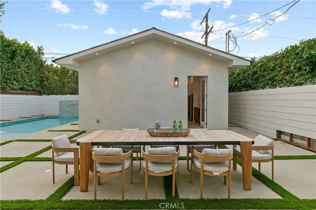 a view of a patio with table and chairs with wooden floor and fence