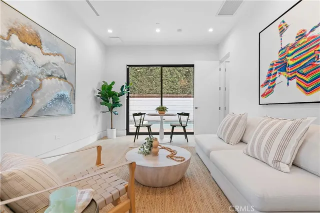 a living room with furniture a refrigerator and a dining table