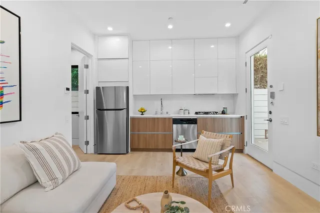 a living room with stainless steel appliances kitchen island furniture and a dining table