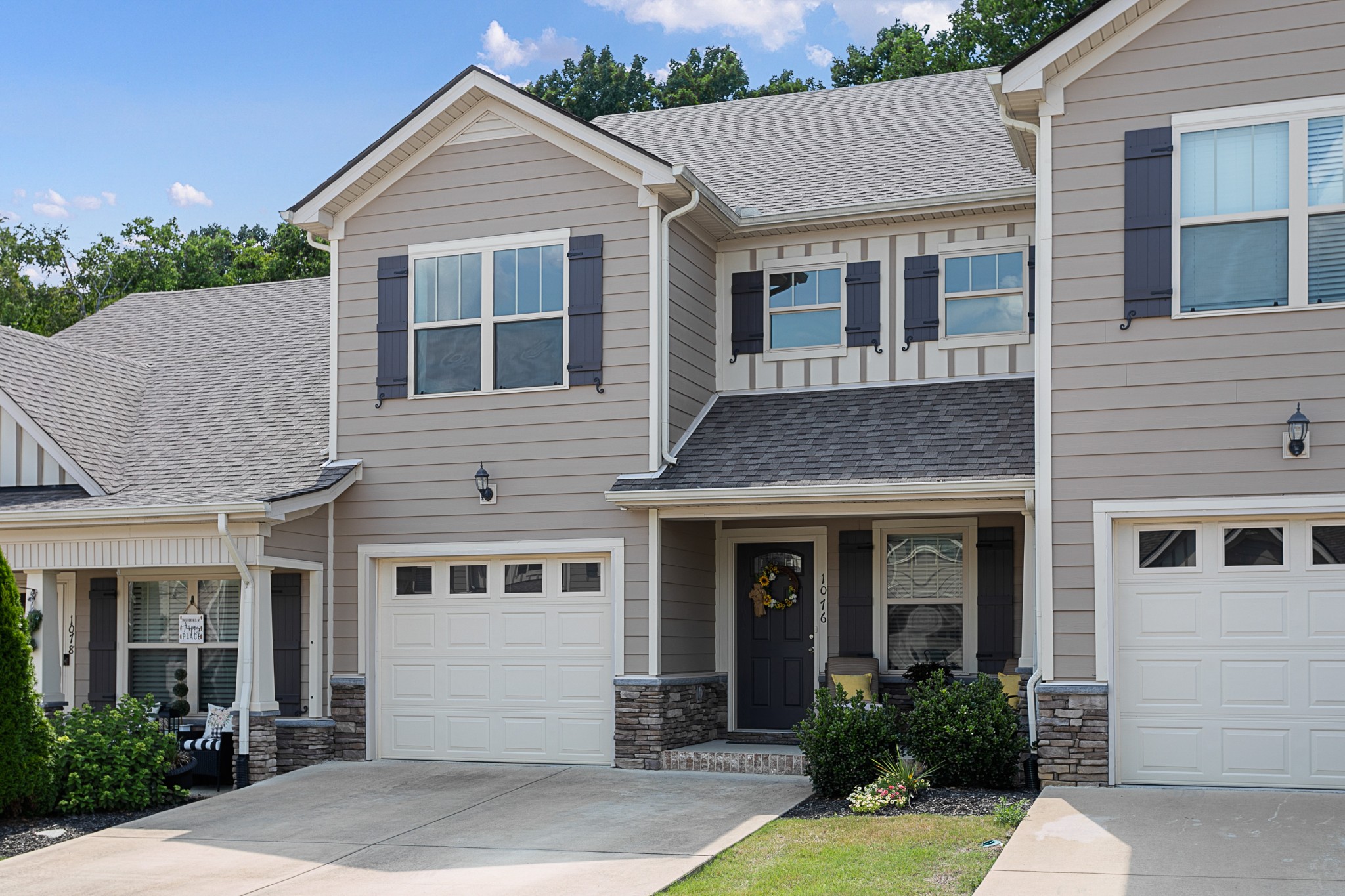 1076 Neeleys Bend East Spring Hill, TN 37174 - Photo 2 of 27 a view of a white house with a yard plants and large tree