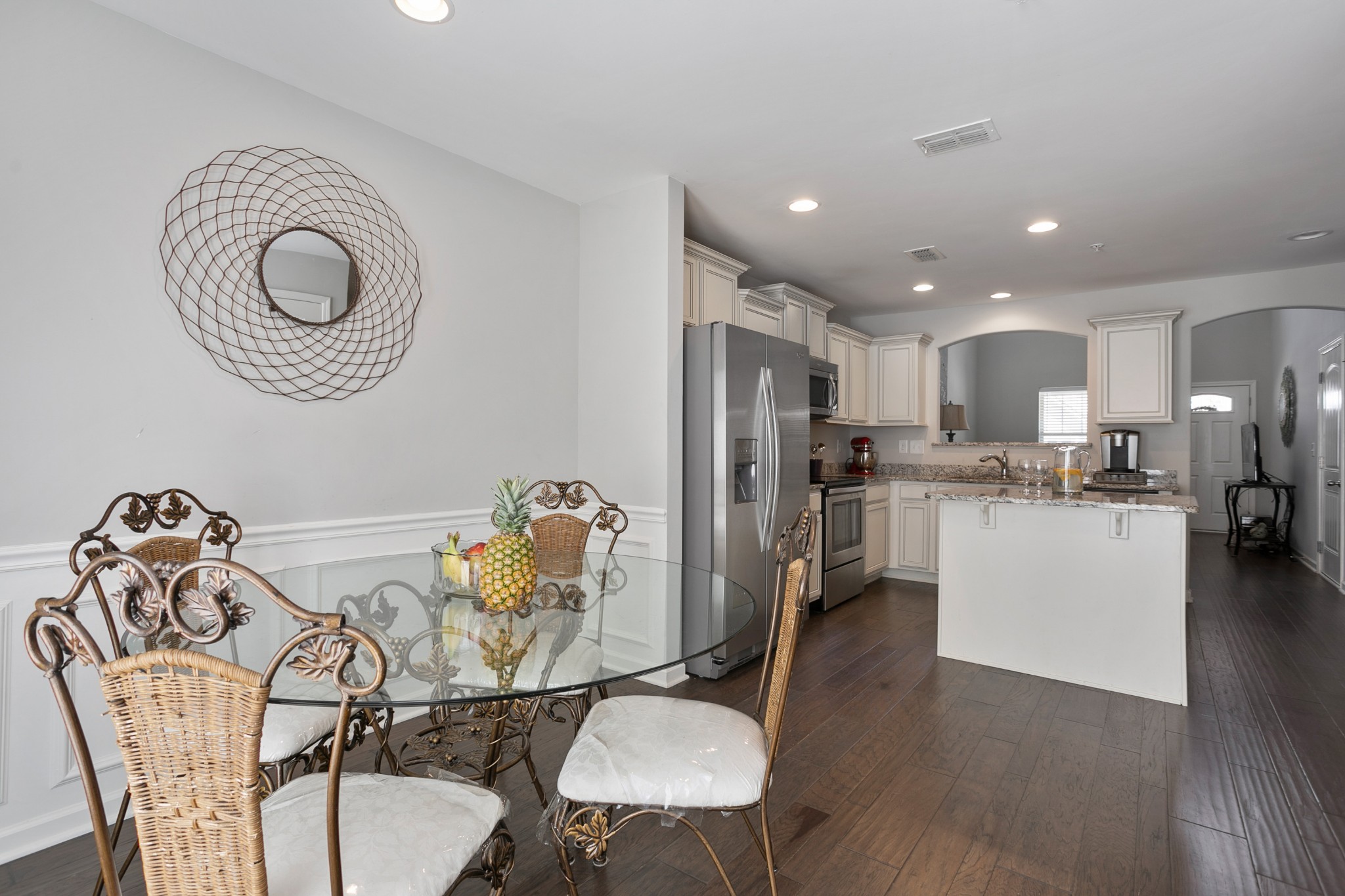 1076 Neeleys Bend East Spring Hill, TN 37174 - Photo 12 of 27 a kitchen with stainless steel appliances granite countertop a dining table chairs and a refrigerator