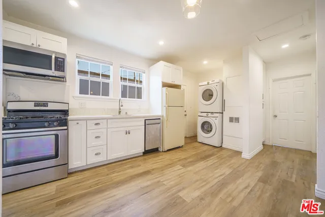 a view of kitchen with stainless steel appliances granite countertop a stove and a refrigerator