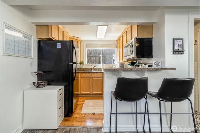 a kitchen with a refrigerator a stove and chairs