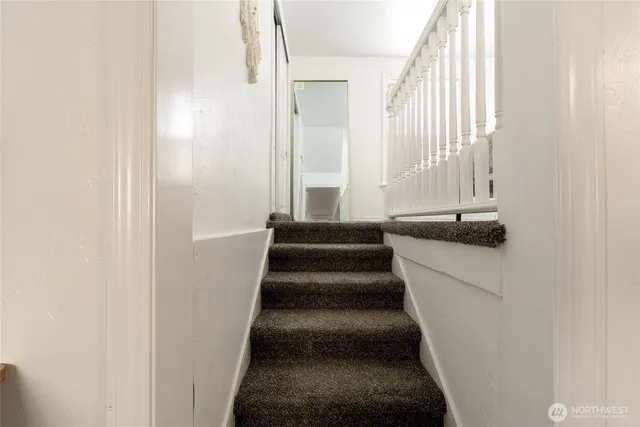 a view of staircase with white walls and a window