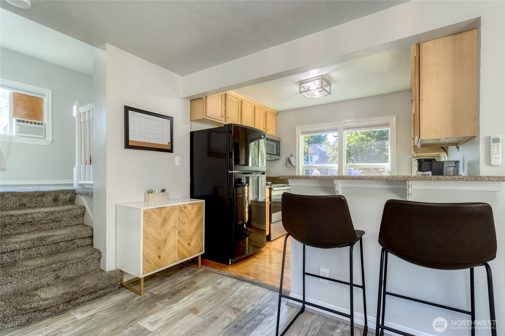 15 Eagan Street Walla Walla, WA 99362 - Photo 6 of 20 a kitchen with stainless steel appliances granite countertop a stove a refrigerator a sink a dining table and chairs with wooden floor