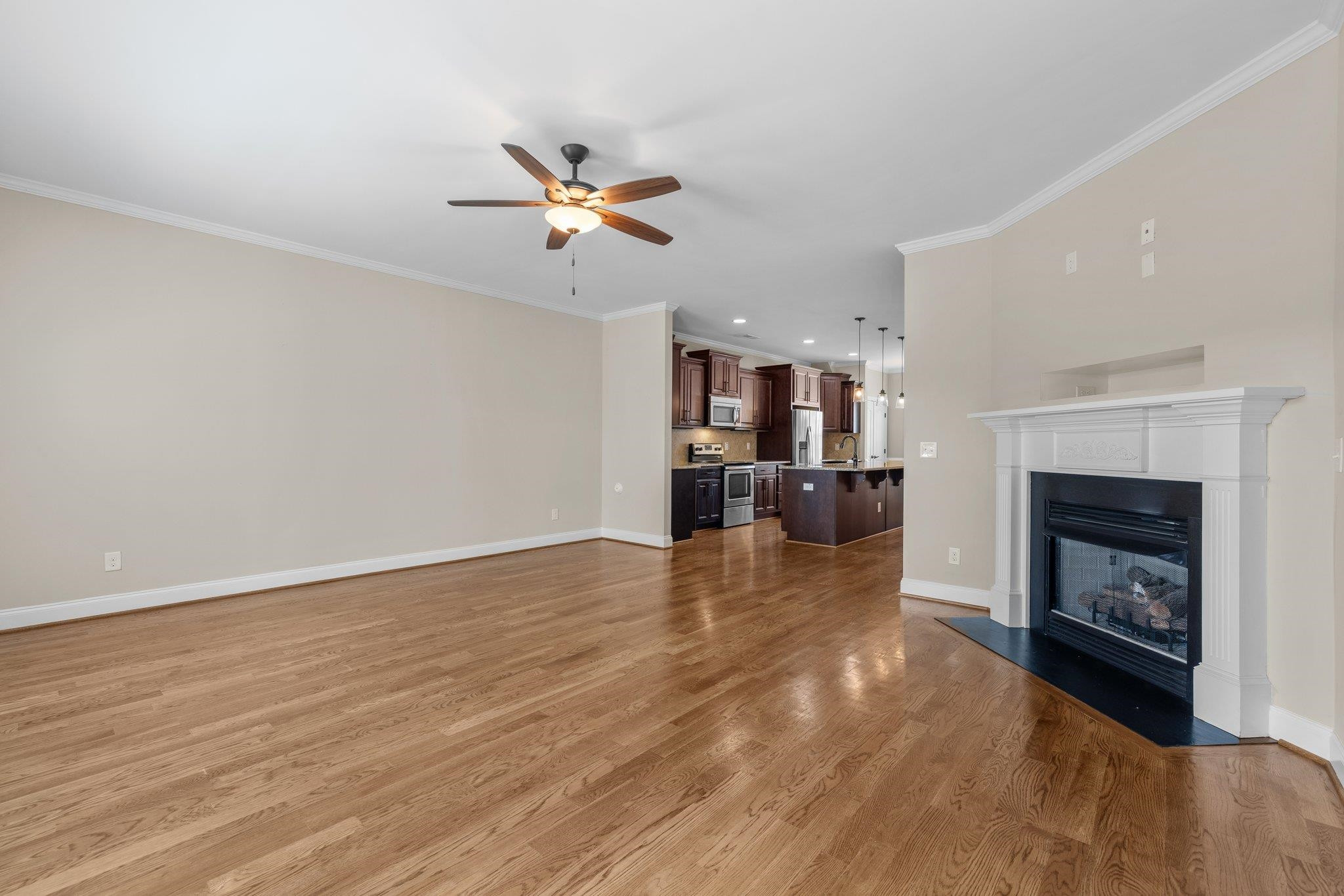 905 Shoofly Path Apex, NC 27502 - Photo 12 of 31 a view of a livingroom with a fireplace a ceiling fan a fireplace and windows