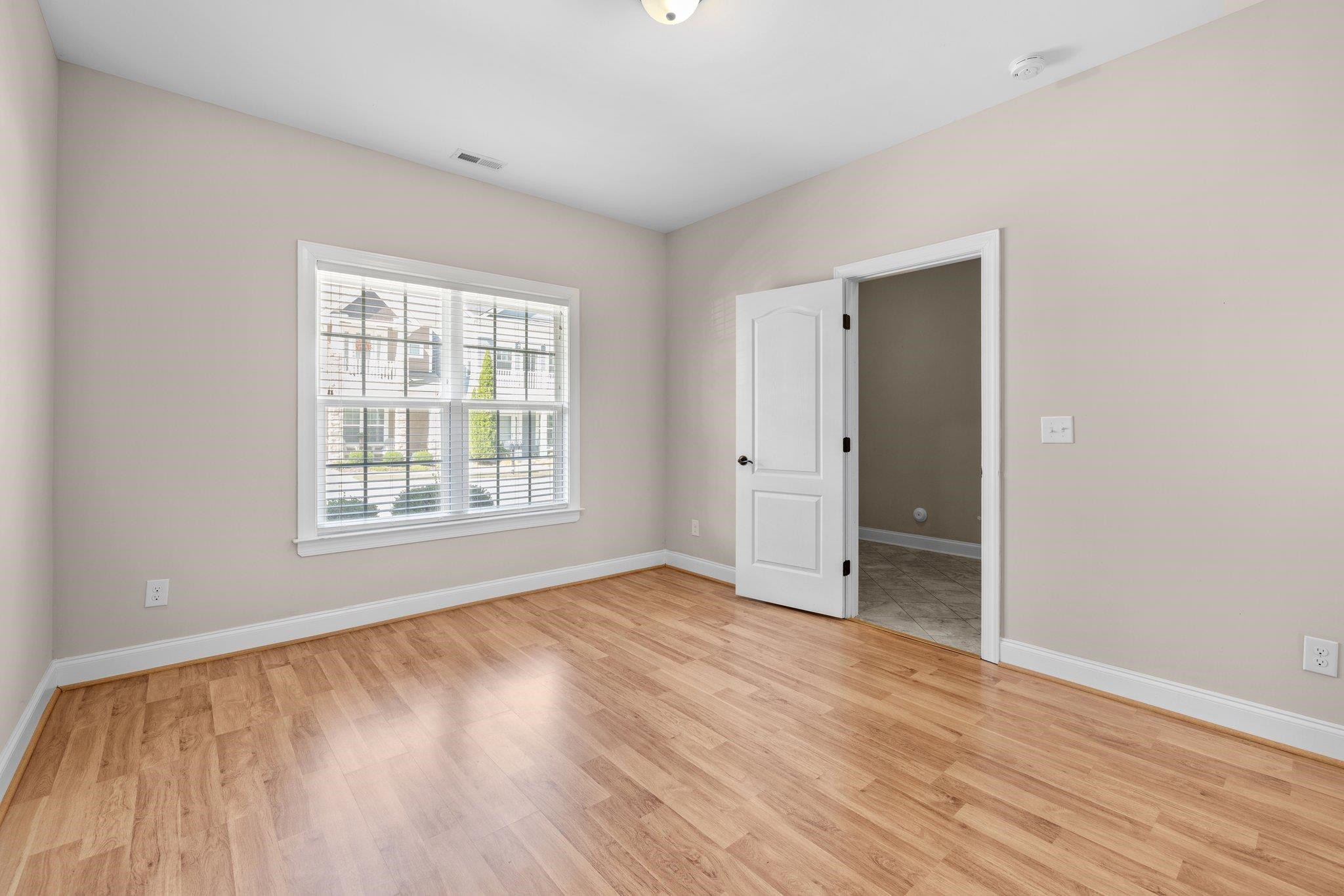 905 Shoofly Path Apex, NC 27502 - Photo 13 of 31 an empty room with wooden floor and windows