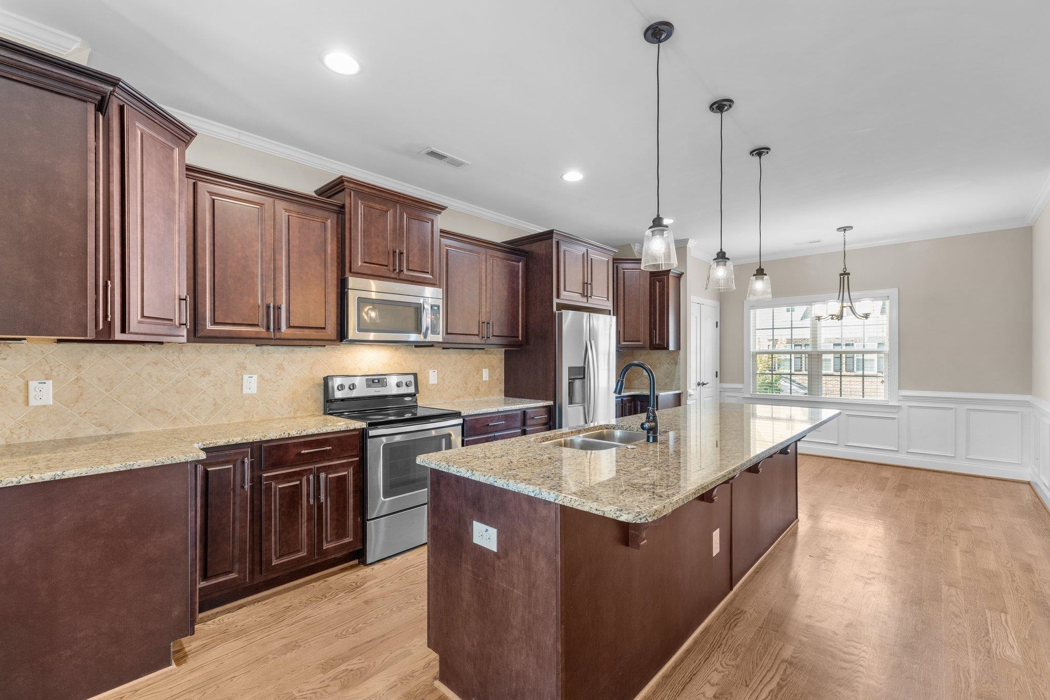 905 Shoofly Path Apex, NC 27502 - Photo 3 of 31 a kitchen with stainless steel appliances granite countertop a sink a stove and a refrigerator