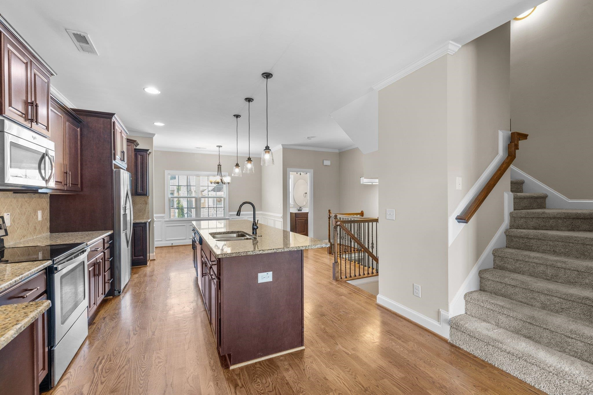 905 Shoofly Path Apex, NC 27502 - Photo 4 of 31 a living room with stainless steel appliances kitchen island granite countertop furniture wooden floor and a kitchen view