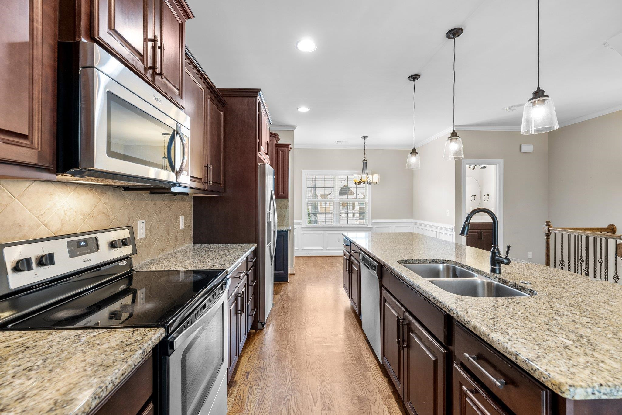 905 Shoofly Path Apex, NC 27502 - Photo 5 of 31 a kitchen with stainless steel appliances granite countertop a sink a stove and a wooden floors