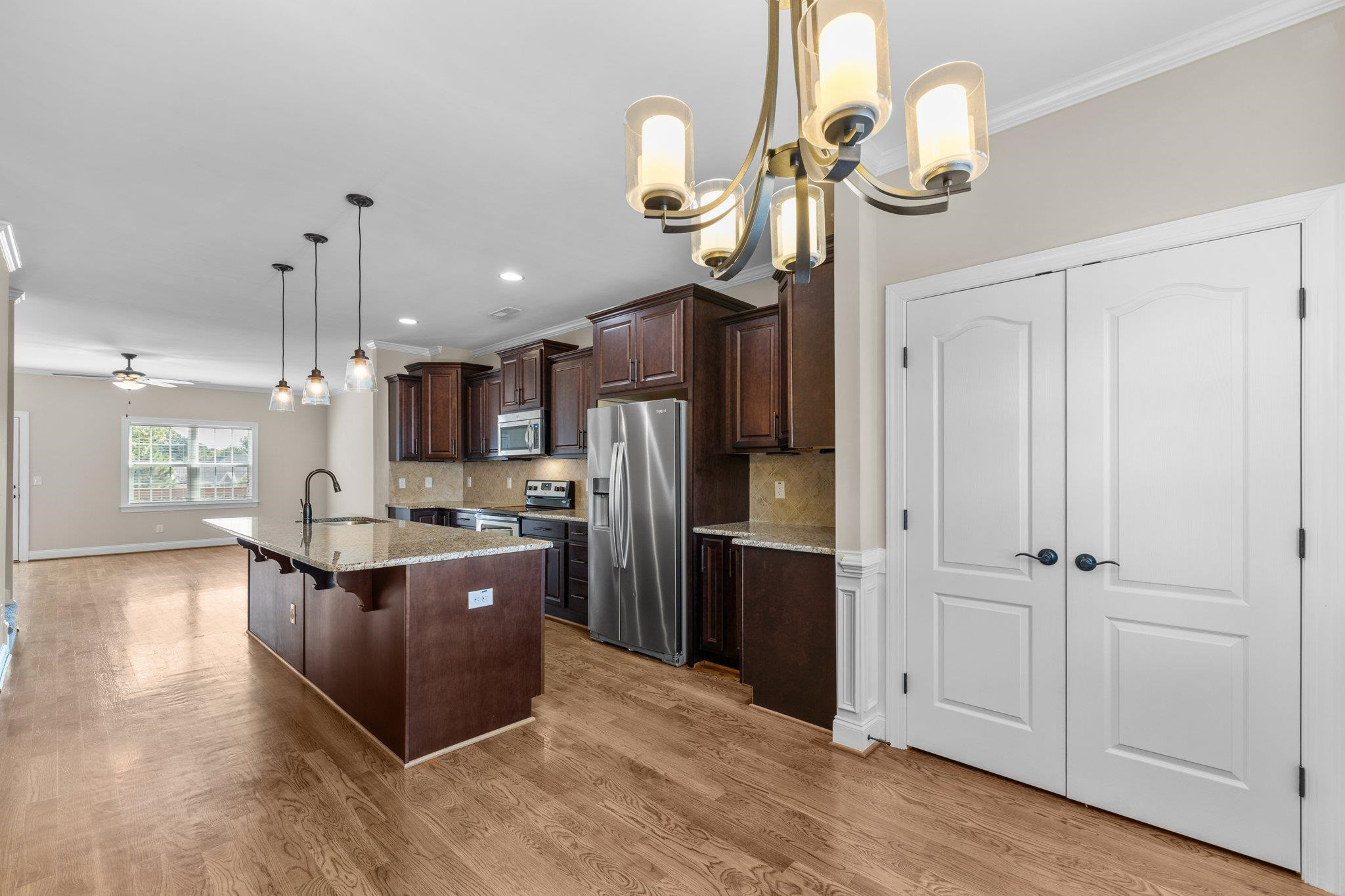 905 Shoofly Path Apex, NC 27502 - Photo 7 of 31 a kitchen with stainless steel appliances granite countertop a refrigerator and a wooden floor