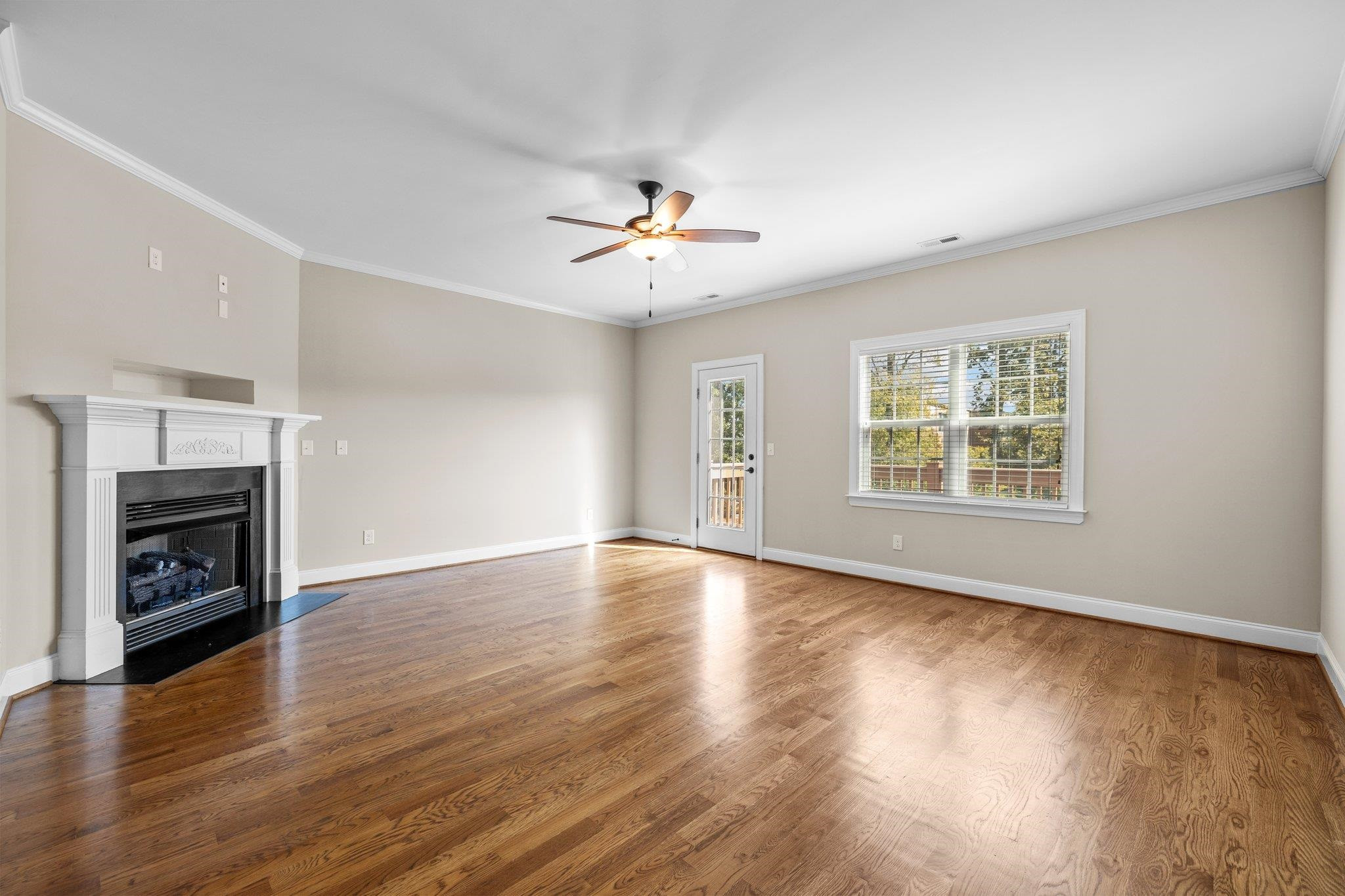 905 Shoofly Path Apex, NC 27502 - Photo 9 of 31 an empty room with wooden floor fireplace and windows