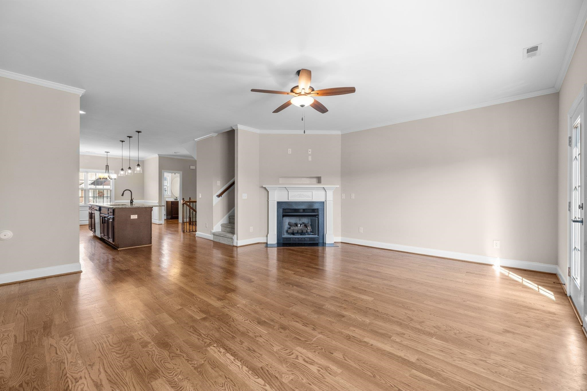 905 Shoofly Path Apex, NC 27502 - Photo 10 of 31 a view of a kitchen and an empty room with wooden floor
