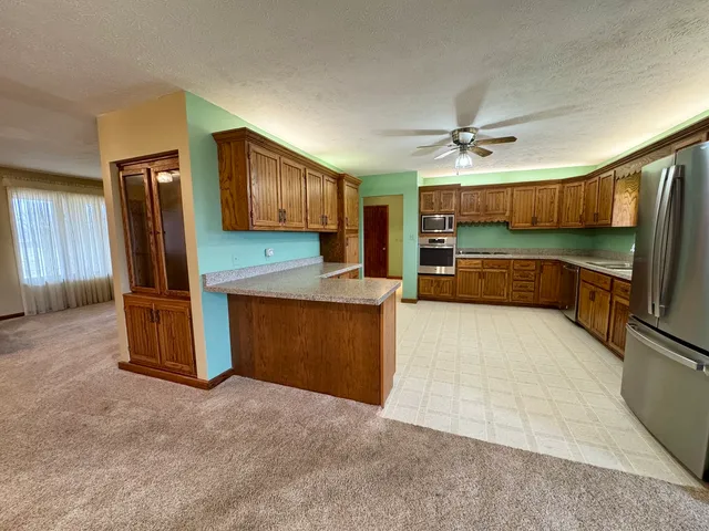 a kitchen with stainless steel appliances granite countertop a refrigerator and a sink