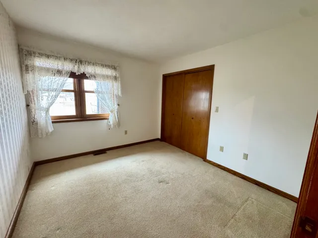 an empty room with windows and closet