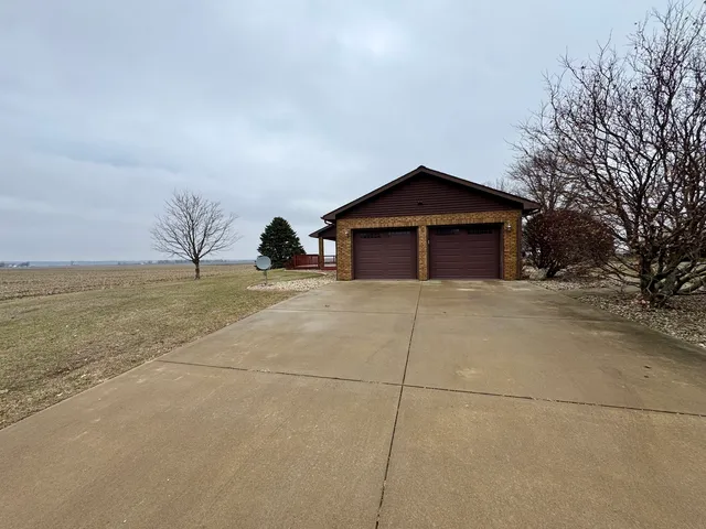 a view of a house with a yard and large tree