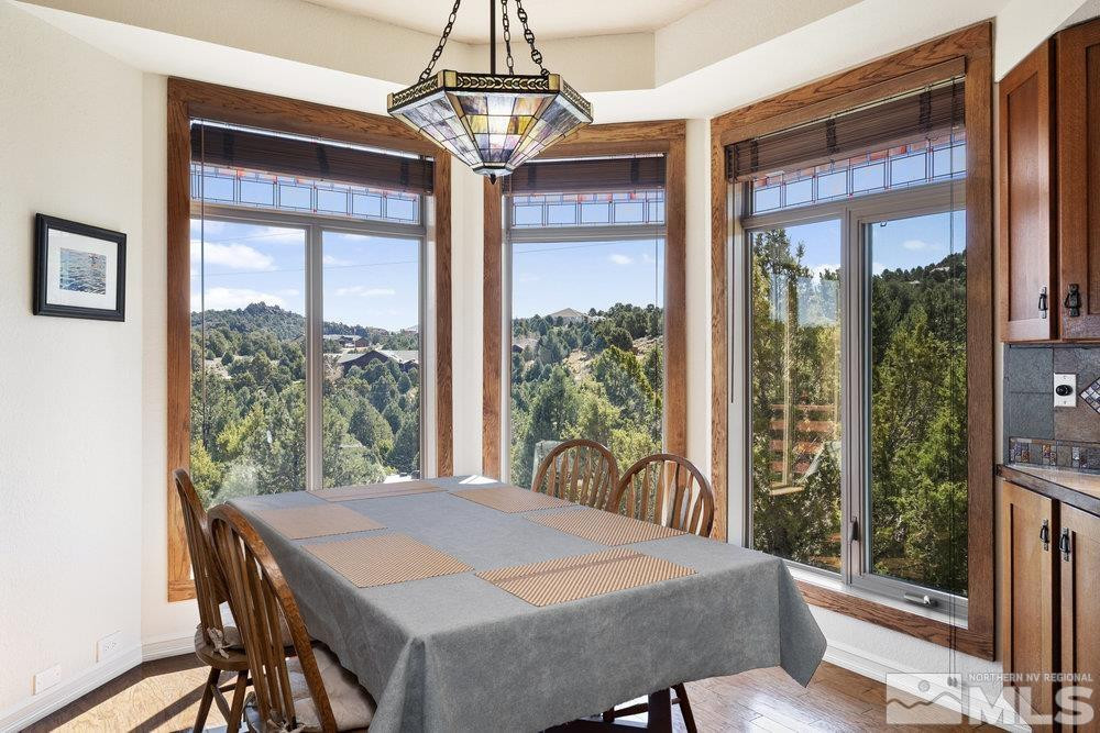 21860 Bowie Road Reno, NV 89521 - Photo 11 of 24 a view of a dining room with furniture large windows and wooden floor