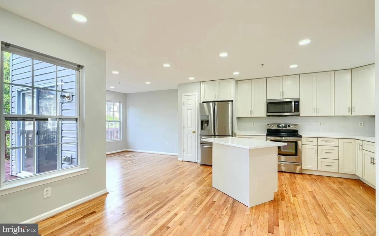 9863 Decatur Road Middle River, MD 21220 - Photo 12 of 33 a kitchen with stainless steel appliances granite countertop a refrigerator oven a sink dishwasher and a oven with wooden floor