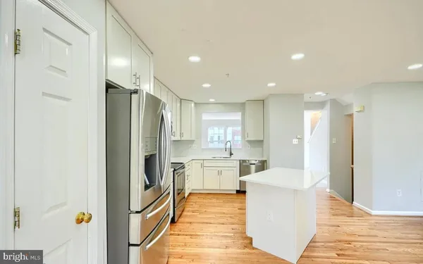 a kitchen with stainless steel appliances a refrigerator and a stove top oven