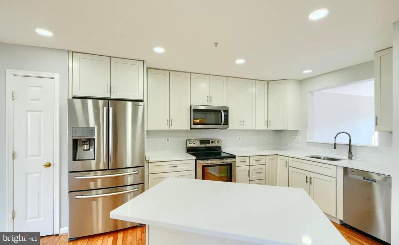 9863 Decatur Road Middle River, MD 21220 - Photo 18 of 33 a kitchen with white cabinets and stainless steel appliances