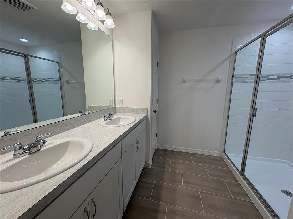 2529 Starry Point St. Cloud, FL 34769 - Photo 16 of 21 a bathroom with a double vanity sink and a mirror