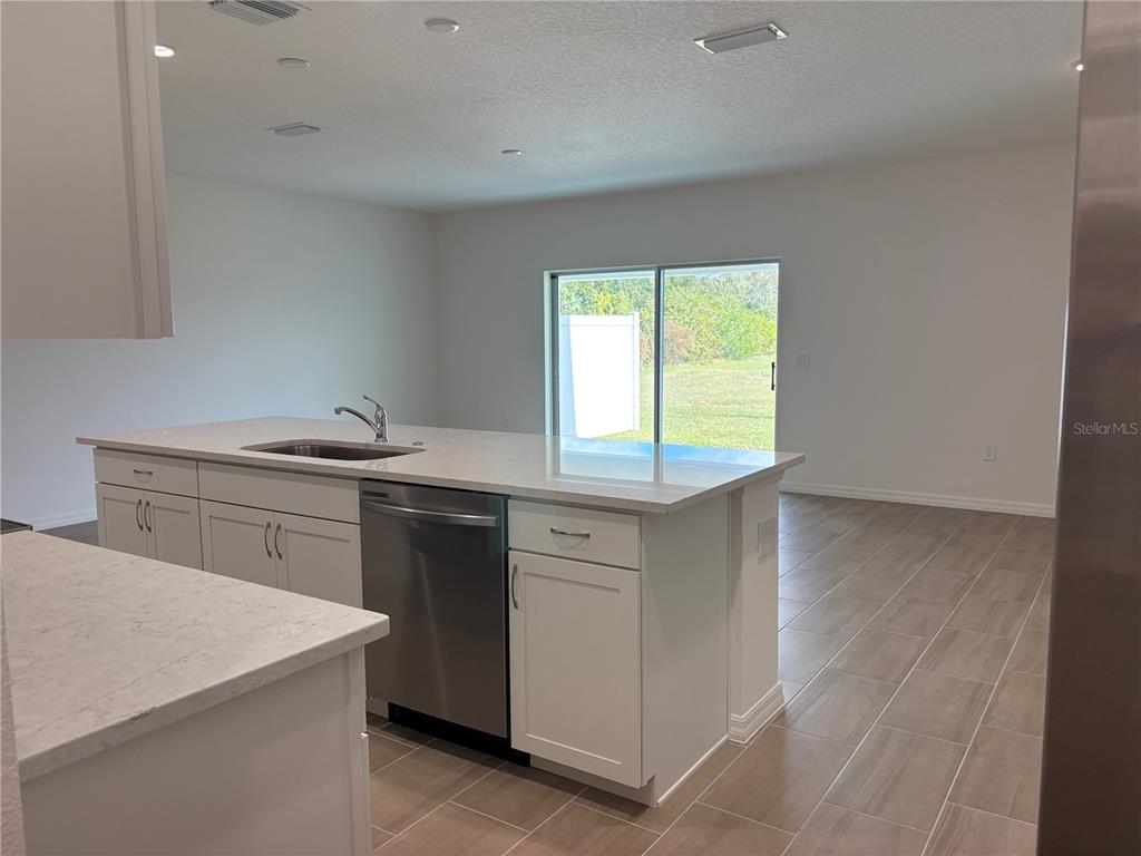 2529 Starry Point St. Cloud, FL 34769 - Photo 6 of 21 a kitchen with a sink stove and cabinets