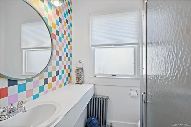 a bathroom with a sink a mirror and painting on the wall