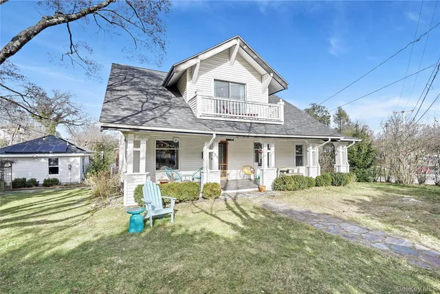 a front view of a house with a garden and chairs