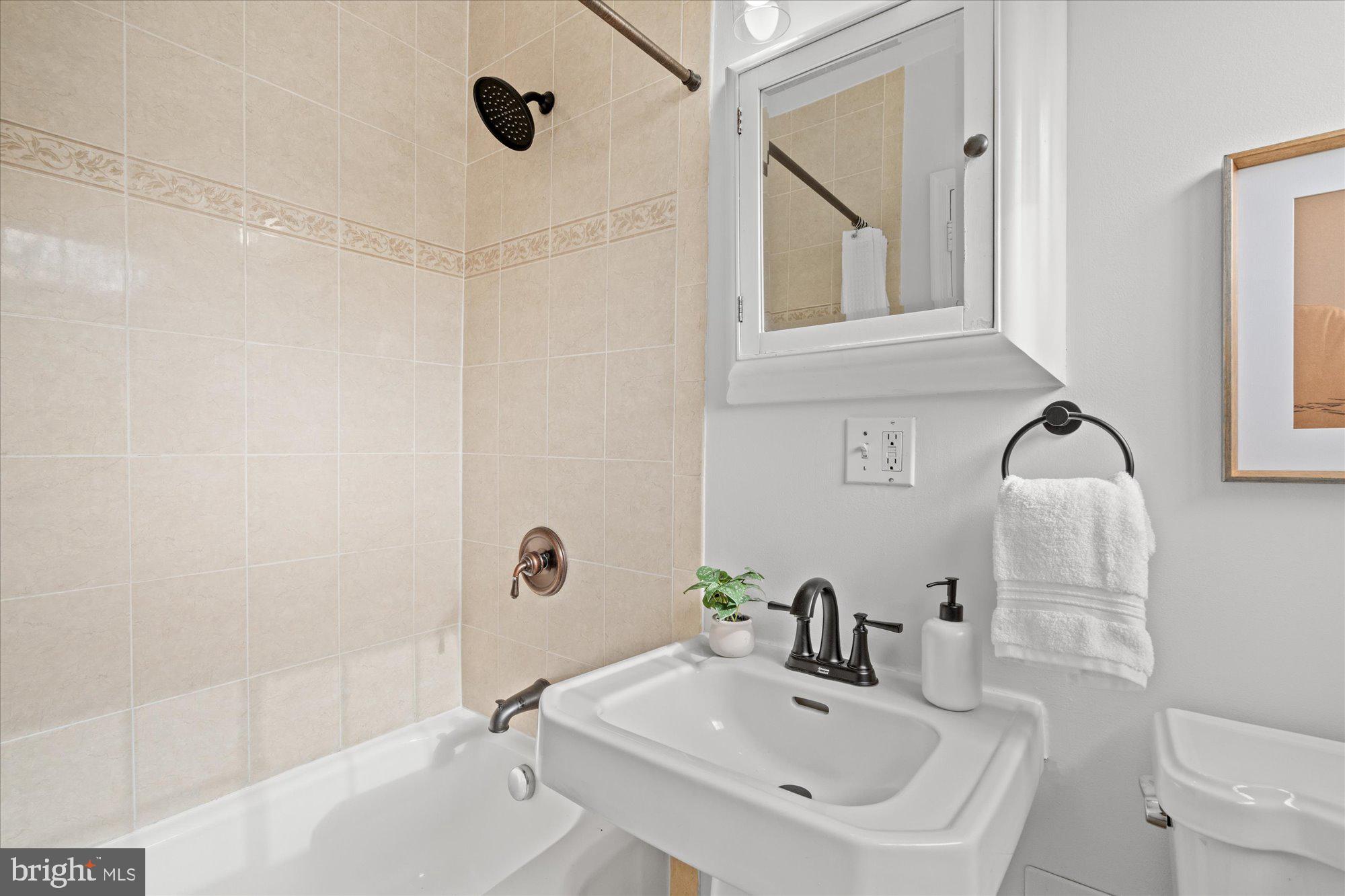 3206 Gunston Road Alexandria, VA 22302 - Photo 22 of 25 a bathroom with a sink and mirror with bathtub