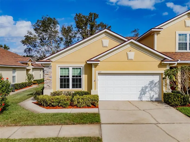 a view of a white house with a yard and potted plants