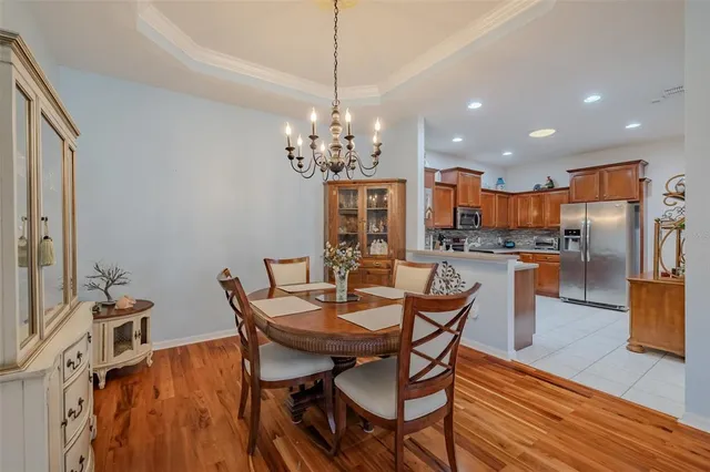 a dining room with furniture a chandelier and wooden floor