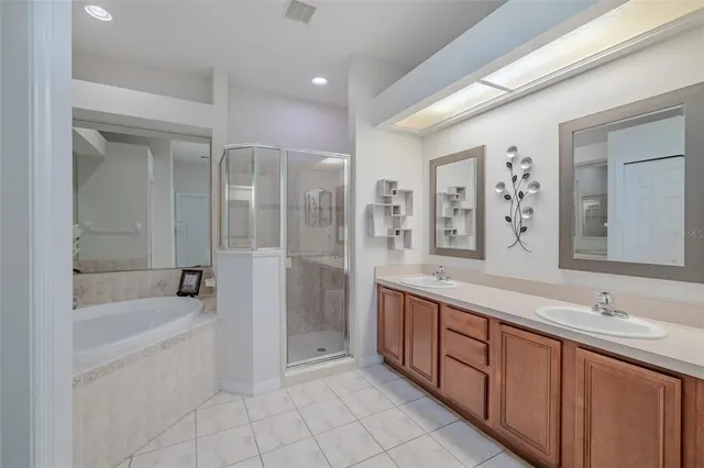 a spacious bathroom with a tub sink shower and mirror