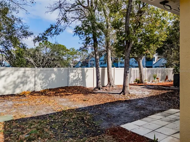 a view of a backyard with wooden fence