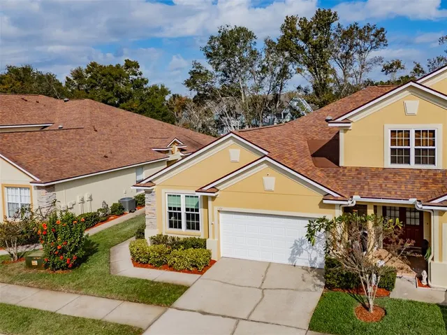 a view of a white house with a yard and potted plants