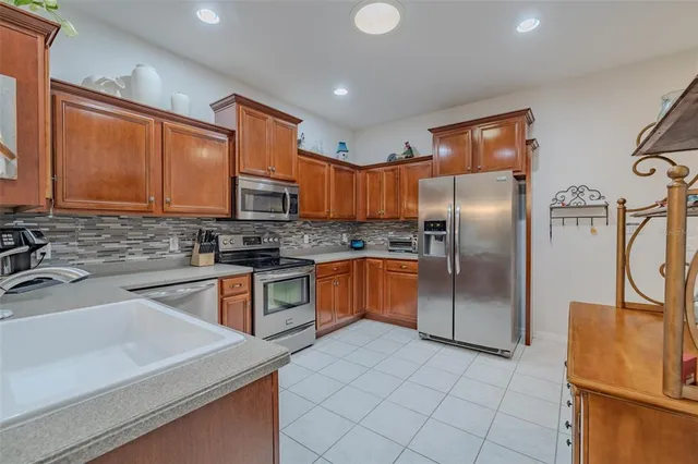 a kitchen with stainless steel appliances granite countertop a refrigerator sink and microwave