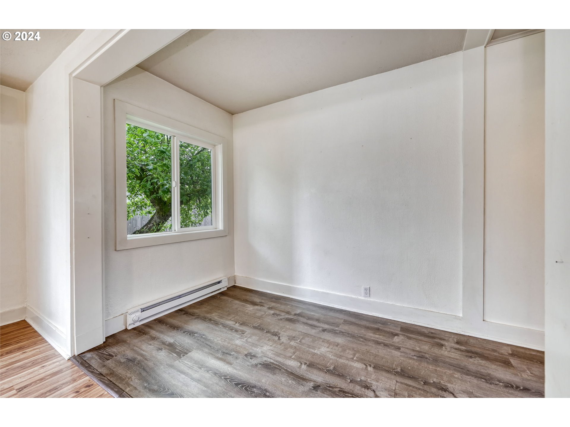614 Mill Street Springfield, OR 97477 - Photo 10 of 37 a view of an empty room with wooden floor and a window