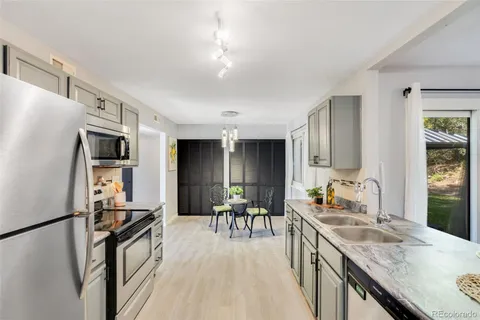 a kitchen with stainless steel appliances granite countertop a refrigerator stove microwave and sink