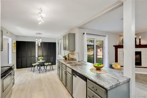 a kitchen with granite countertop a stove a sink and a refrigerator