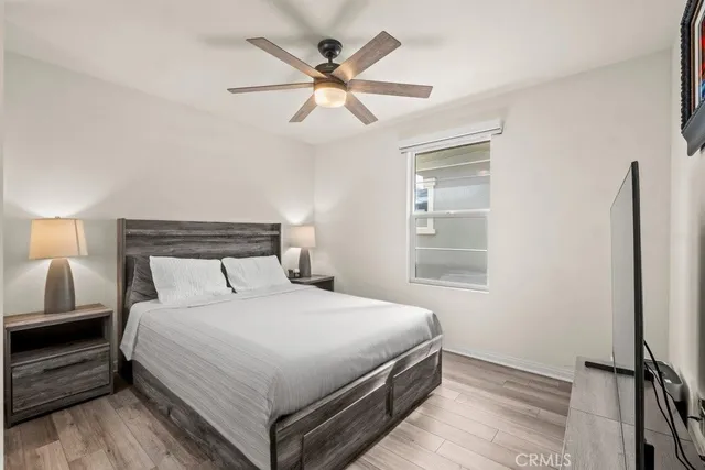 a bedroom with a large bed and a ceiling fan